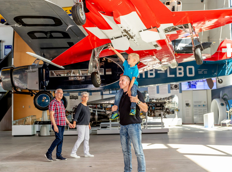 Ein Vater ist mit einem Kind unter eine Flugzeug in der Flughalle