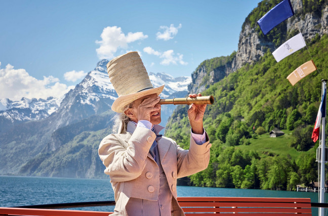 Legends of Lake Lucerne Ein Mann in alter historischer Kleidung schaut durch ein Fernrohr.