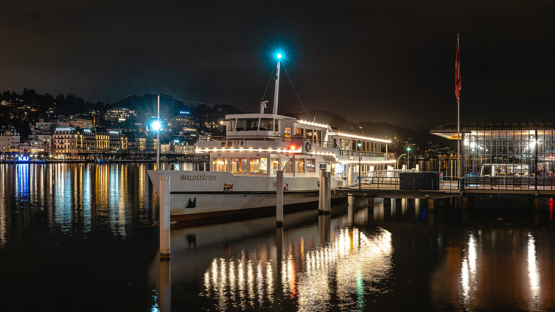 Fondue- und Raclette-Schiff - Motorschiff Waldstätter Das Motorschiff Waldstätter steht bei Nacht am Steg 1 in Luzern und ist beleuchtet. Das Schiff steht bereit für die Fondue- und Raclette-Fahrt auf dem Vierwaldstättersee.