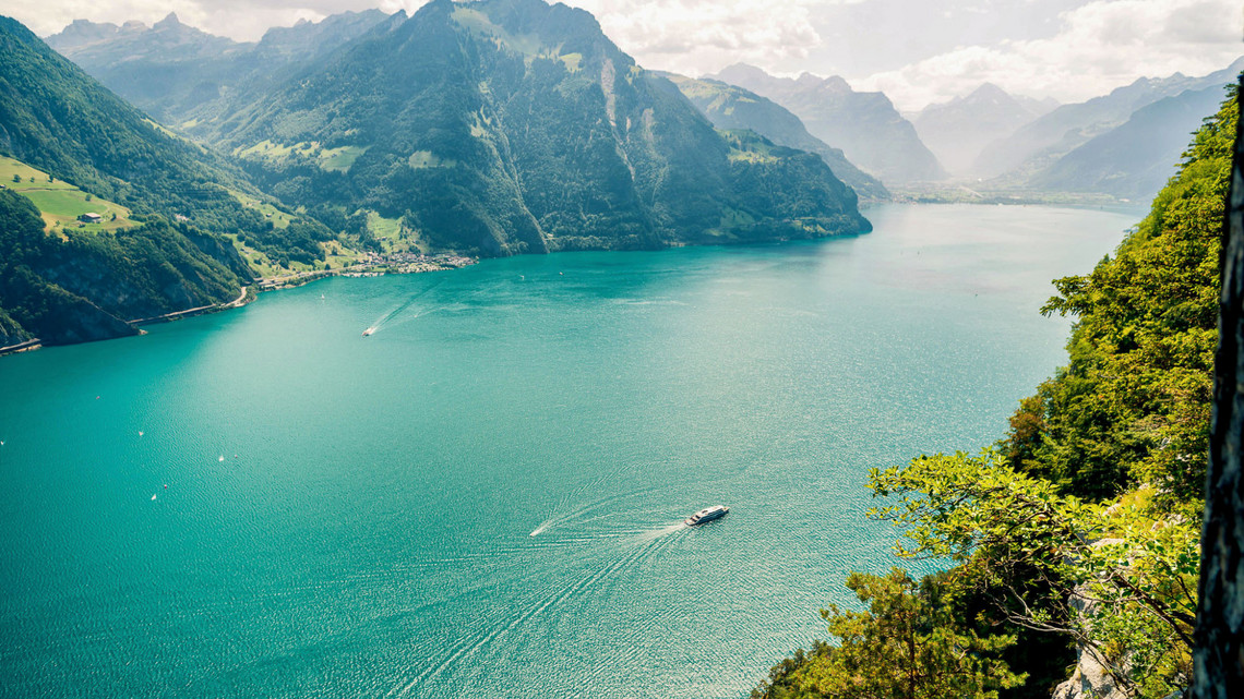 Sommer auf dem Vierwaldstättersee Urnersee Becken von oben fotografiert. See schimmert türkisblau, die Wälder sind saftig grün.