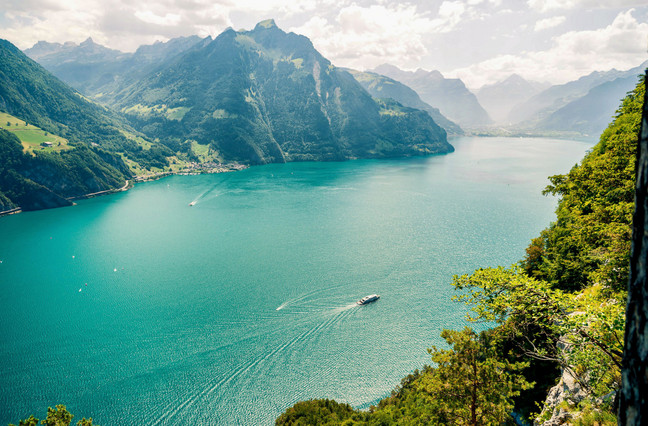 Einzigartiger Arbeitsort Urnersee Becken von oben fotografiert. See schimmert türkisblau, die Wälder sind saftig grün.