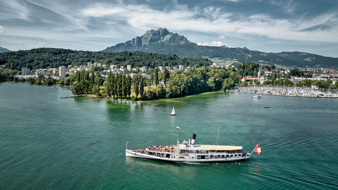 The steamship Gallia photographed from the side while sailing on the turquoise blue water.