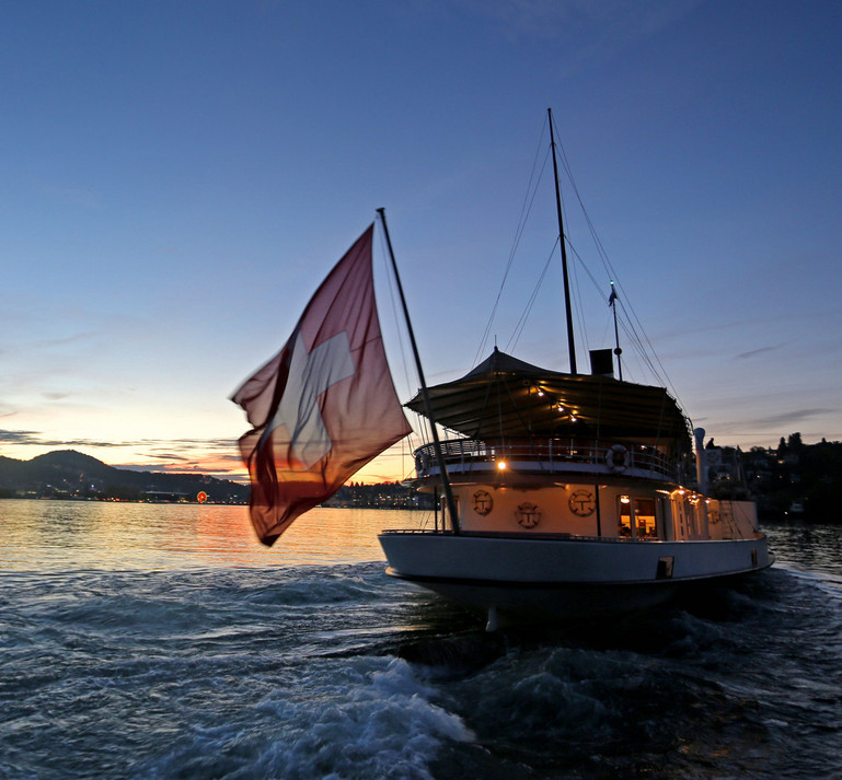 The paddle steamer on a cruise in the nightly natural scenery towards Lucerne.