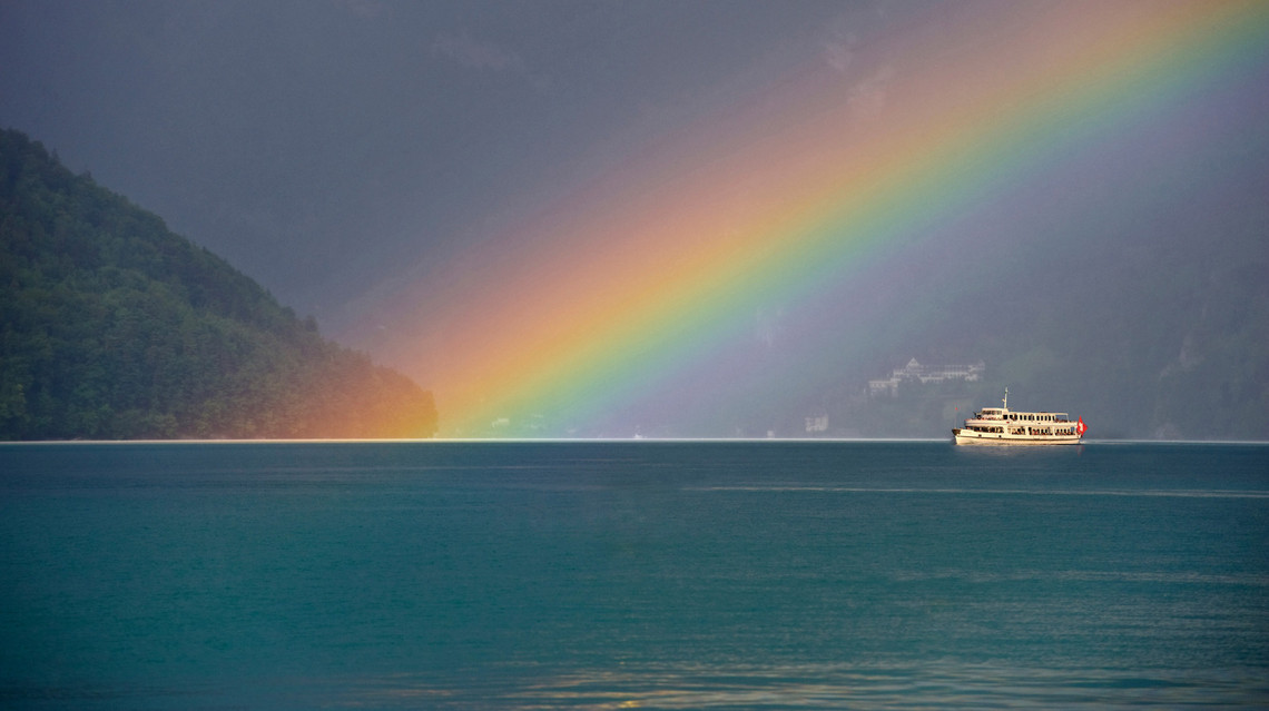 Schiff mit Regenbogen Ein Schiff fährt auf dem See neben einem grossen Regenbogen