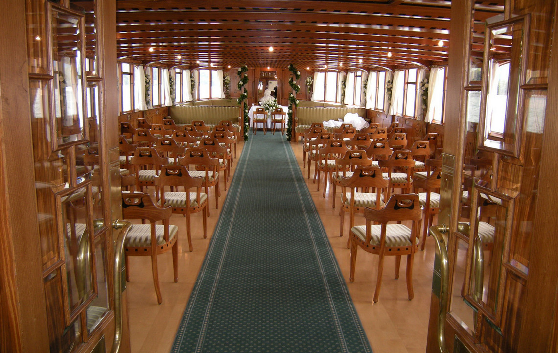 Salle du bateau à vapeur Schiller avec des tables fixes La salle du bateau à vapeur Schiller est magnifiquement préparée pour un dîner de mariage.