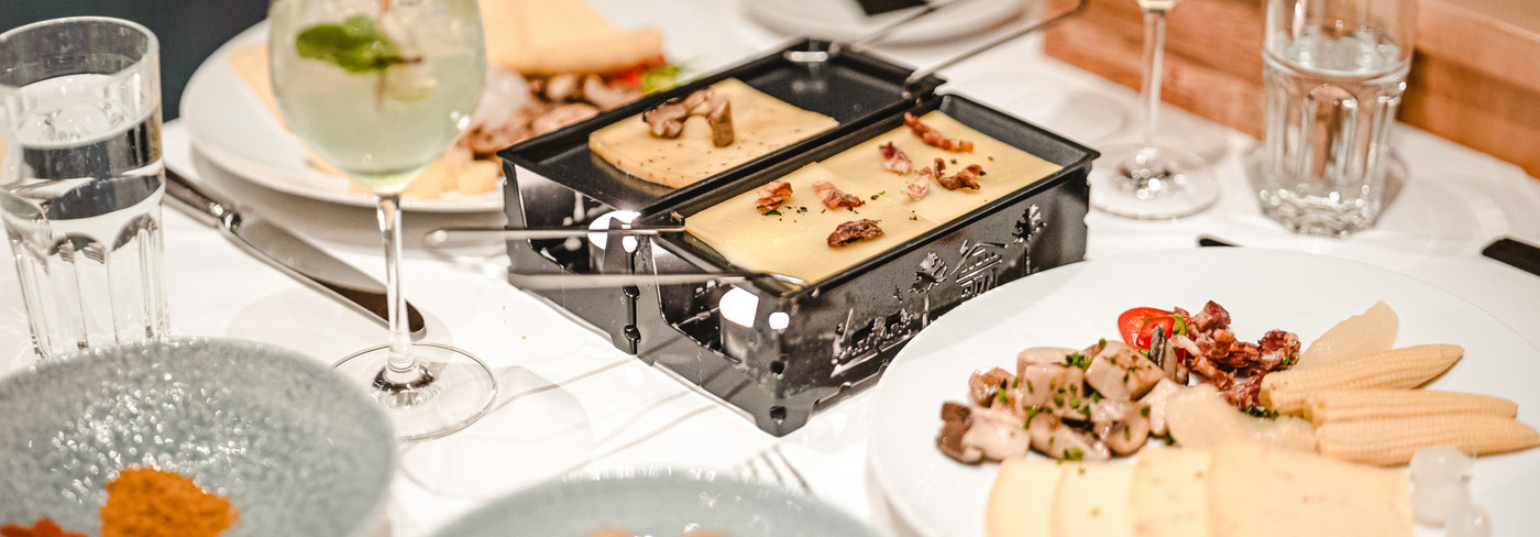 Eating raclette on the motorboat. You can see the table with the raclette oven and the cheese.