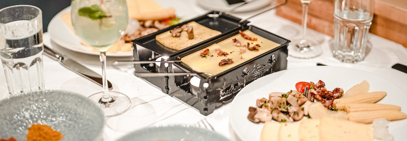 Eating raclette on the motorboat. You can see the table with the raclette oven and the cheese.