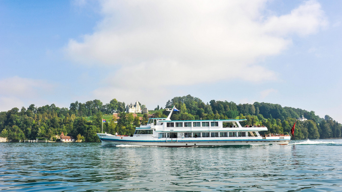 Das Motorschiff Brunnen fährt bei sonnigem Wetter auf dem Vierwaldstättersee.