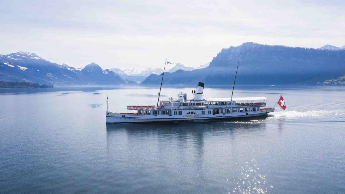 Drohnenaufnahme Stadt Luzern 5 Das Dampfschiff ist klar von der Seite zu sehen mit Bergen im Hintergrund.