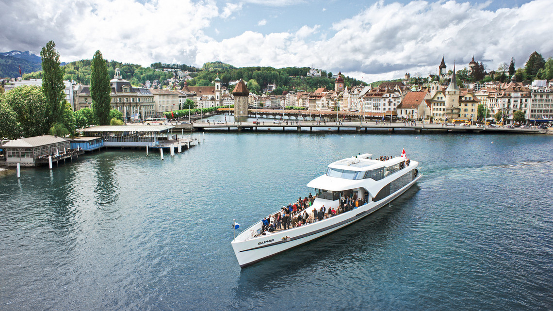 Conduire le bateau à moteur Saphir Le bateau à moteur Saphir navigue sur le lac des Quatre-Cantons par temps légèrement nuageux.