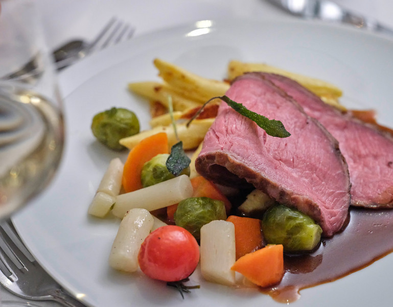 Ein Bild mit einem gedeckten romantischen Tisch mit Rosenblätter für den Valentinstag.