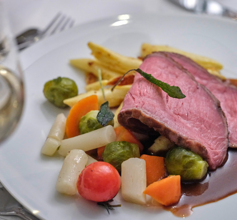 Ein Bild mit einem gedeckten romantischen Tisch mit Rosenblätter für den Valentinstag.