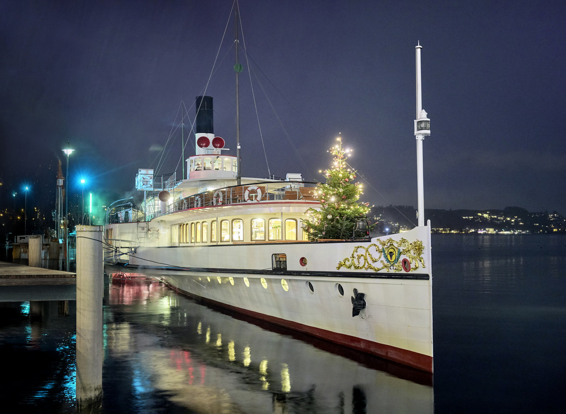 Schiffsmiete Firmenfeier - Dampfschiff Uri während der Adventszeit Stehendes weihnachtlich dekoriertes Dampfschiff Uri auf dem Vierwaldstättersee bei Nacht.
